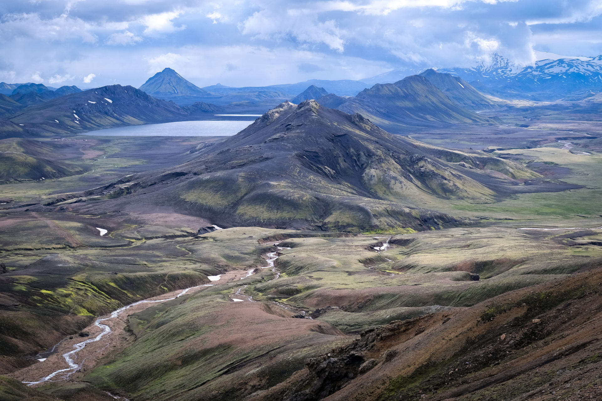 Highland valley with lake and distant peaks