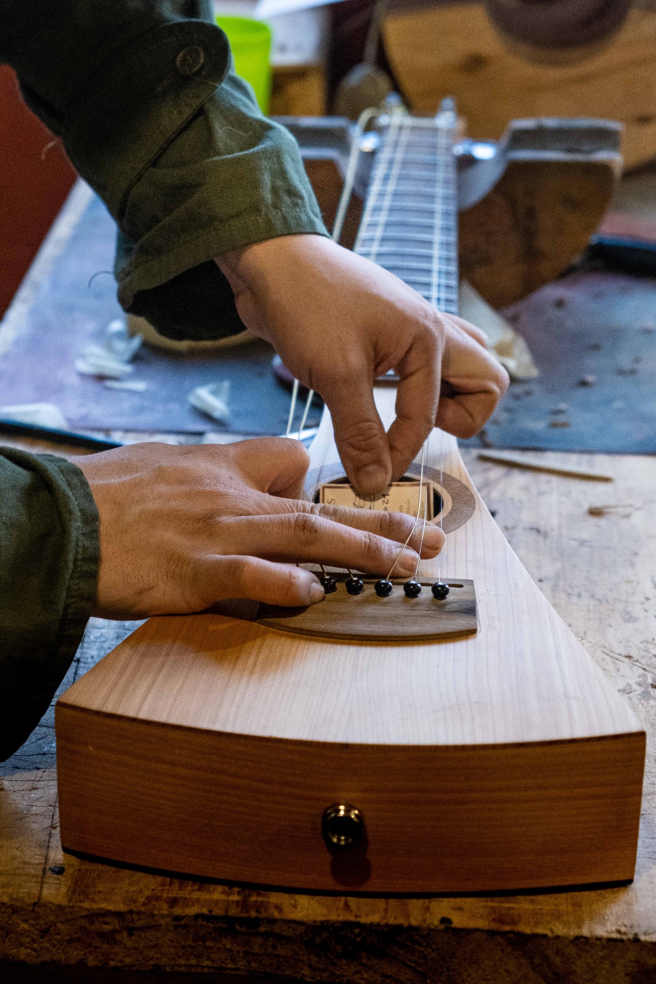 Luthier stringing a handmade guitar